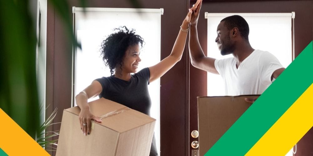 Man and woman giving each other a high five while moving boxes