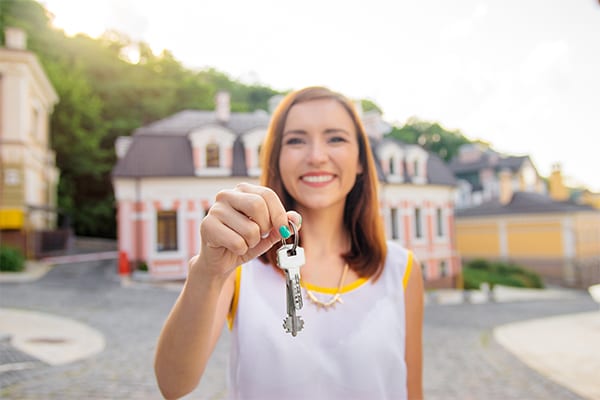 Woman happily holding keys to her new home